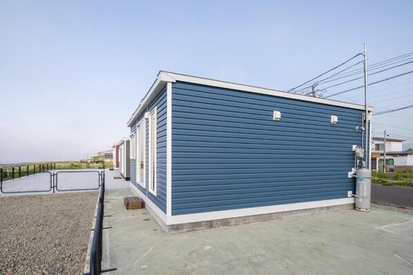 Un bâtiment d’un seul étage, doté d’un toit plat, d’une allée en béton et d’une clôture en métal.