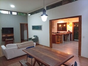 Un espai de vida modern amb zona de menjador, petita cuina i televisió.