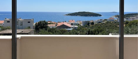 A balcony with a view of the sea and a small island.