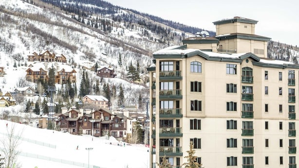 Un hotel de varios pisos con balcones, ubicado en una zona montañosa con paisajes nevados.