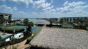 A resort with a pool, a thatched-roof structure, and a view of the marina. - Delightful and trendy 1 bedroom -1 bath condo F403 (Marco Island)