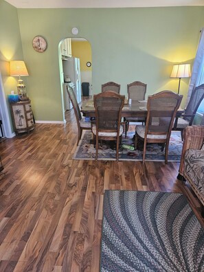 A dining area with a wooden table, four chairs, a rug, and a lamp. - Serene 4-bedroom house with AC in Spring Lake with old fashioned charm. (Spring Lake)