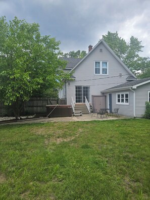 A two-story house with a front porch, a covered patio, and a fenced backyard. - Serene 4-bedroom house with AC in Spring Lake with old fashioned charm. (Spring Lake)