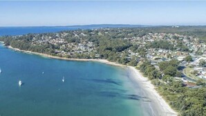An aerial view of a coastal town with a beach, boats, and residential buildings. - Beach Street Studio Vincentia (Vincentia)