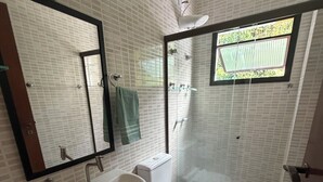 A bathroom with a sink, toilet, and shower. - Flat 38 Ubatuba Toninhas (Ubatuba)