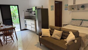 A compact living space with a kitchenette, a sofa, a bed, and a dining area. - Flat 38 Ubatuba Toninhas (Ubatuba)