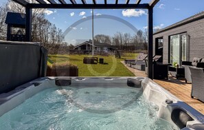 A hot tub with a view of a house and outdoor seating area. - Pet friendly home in Glesborg with WiFi (Glesborg)