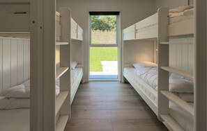 A corridor with bunk beds leading to a door with a view of a grassy area. - Pet friendly home in Glesborg with WiFi (Glesborg)