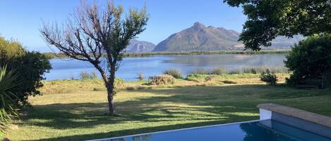 A swimming pool with a view of a lake and mountains.