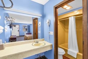 Bañera con ducha, toallas, jabón, shampoo