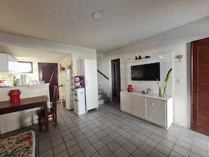 Eine moderne Küche mit Essbereich, integriertem Fernseher und einer Treppe zu einer weiteren Ebene.