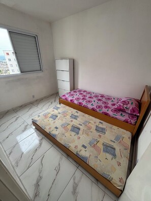 Una habitación pequeña con cama, ventana y armario.