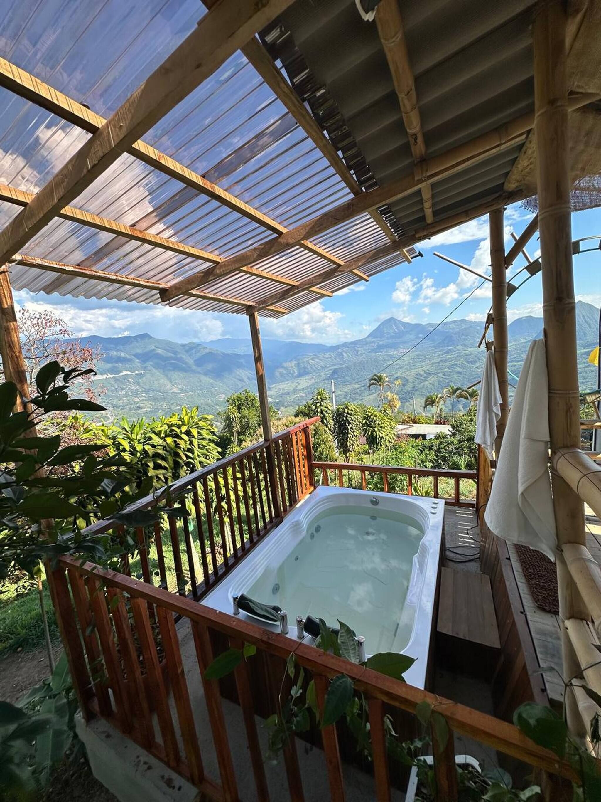 A hot tub on a wooden deck with a view of mountains.
