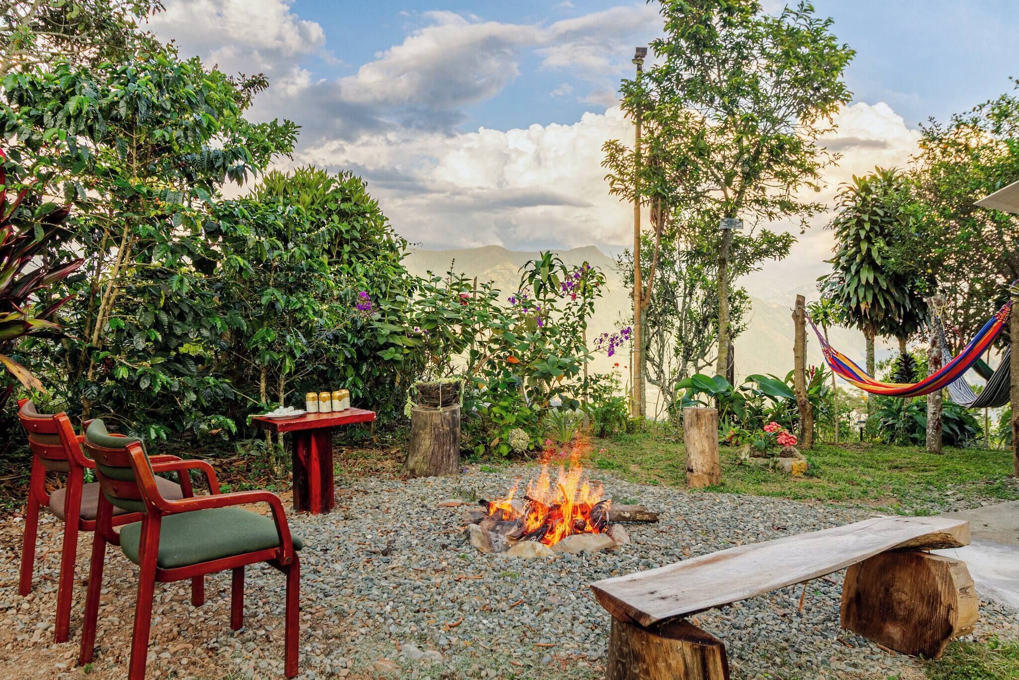 An outdoor seating area with chairs and a table, a fire pit, and a hammock.