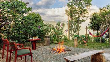 An outdoor seating area with chairs and a table, a fire pit, and a hammock.