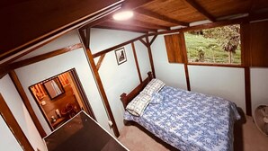 Un dormitorio con cama, ventana y vistas al exterior.
