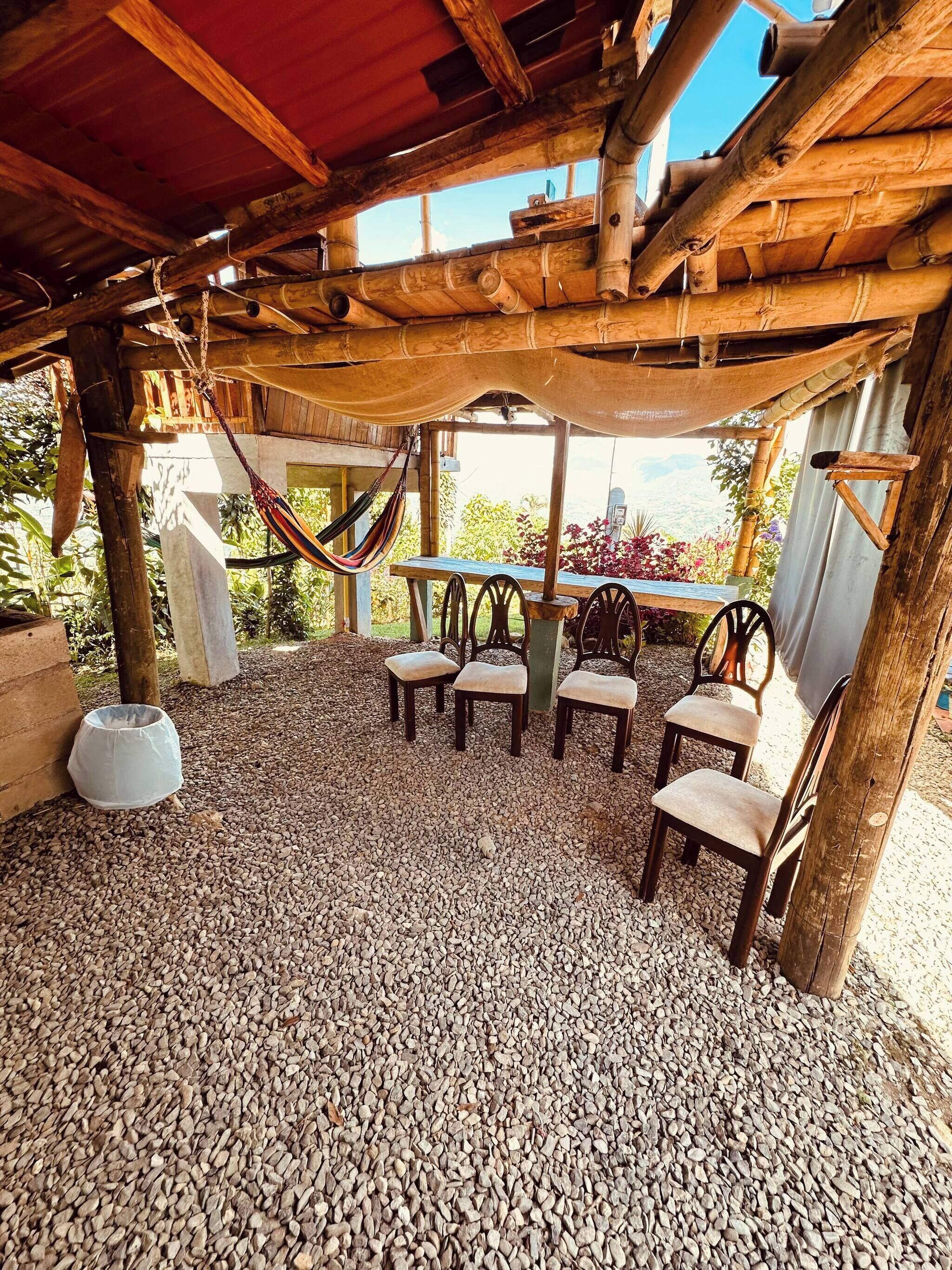 An outdoor seating area with wooden furniture and a hammock.