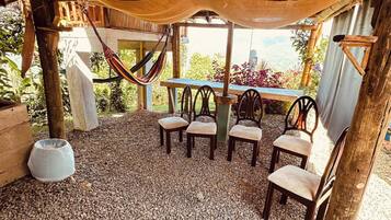 An outdoor seating area with wooden furniture and a hammock.