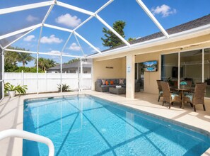 A swimming pool with a covered patio area, a seating area with a sofa and chairs, and a dining table with chairs. - Private Heated Pool, Sleeps 10, King Suite, Near Dining and Boating (Cape Coral)