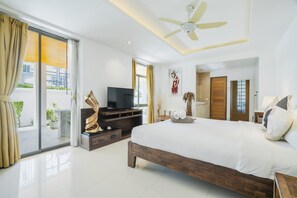 A modern bedroom with a large bed, a television, and a balcony with curtains. - Panoramic Seaview Elevate Villa, Infinity Pool (Rawai)