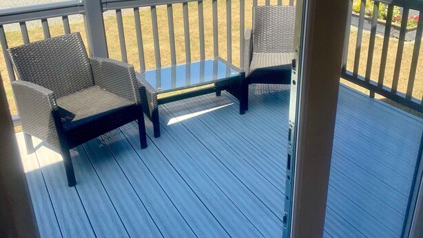 En terrasse med to fletstole og et lille bord.