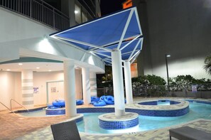 An indoor swimming pool with blue-tiled edges, a covered seating area, and a 'Fireguard Duty' sign. - 2-bedroom condo in soothing Myrtle Beach/ Modern Decor. Stunning View-14th Flr (Myrtle Beach)