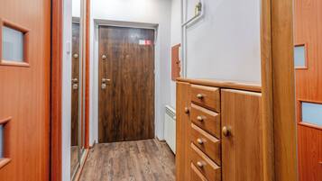 A hallway with wooden doors, a radiator, and a wooden cabinet with drawers.