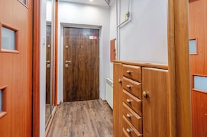 Ein Korridor mit Holztüren, einem Heizkörper und einem Schrank mit Schubladen.