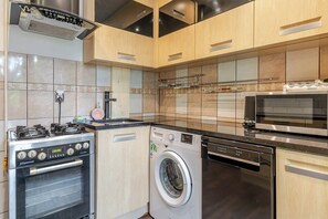 Una cocina moderna con electrodomésticos de acero inoxidable, incluyendo estufa, horno, microondas y lavavajillas.