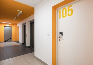 Ein Korridor mit einer Tür, auf der '105' steht, und einer Treppe, die zu einem anderen Raum führt.
