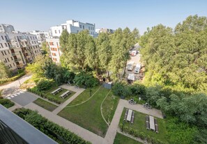 Ein Wohngebiet mit modernen Gebäuden, einem gepflegten Garten mit Wegen und Außenmöbeln.