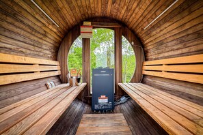 Una sauna con bancos de madera y equipo Harvia.