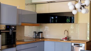 Una cocina moderna con electrodomésticos integrados, encimera de madera y lavavajillas de acero inoxidable.