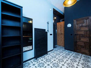 Une pièce avec une armoire noire, une porte en bois et un plancher à motifs.
