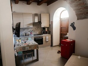 Eine kompakte Küche mit Mikrowelle, Herd und einem roten Kühlschrank.