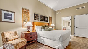A hotel room with a bed, two bedside tables, a chair, and artwork on the walls. - Maui Resort Rentals: Two Luxury Ground Floor Suites with Expansive Lawns Near Beach, Pools and BBQs! (Lahaina)