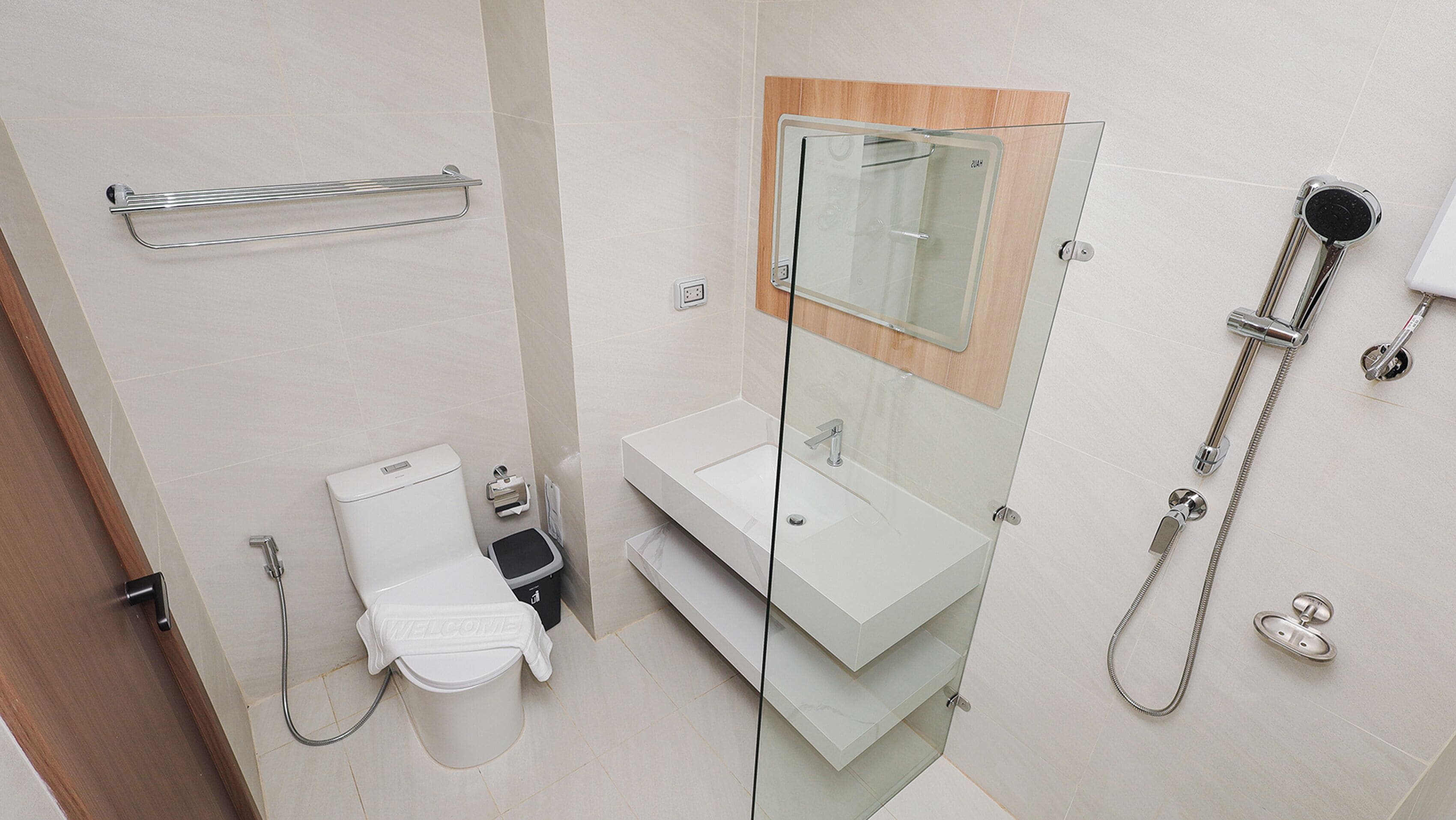 A modern bathroom with a glass shower enclosure, a white sink, and a toilet.