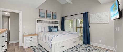 A bedroom with a bed, bedside tables, a ceiling fan, a window with curtains, and a motivational quote on the wall.
