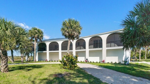 A building with a symmetrical facade, multiple arched windows, and a central entrance. - Sanibel Beach Retreat + Bonus Bungalow! Sleeps 17 • Private Pool (Sanibel)