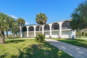 A building with a symmetrical facade, multiple arched windows, and a central entrance. - Sanibel Beach Retreat + Bonus Bungalow! Sleeps 17 • Private Pool (Sanibel)