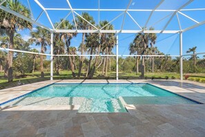 A pool with clear blue water, surrounded by a white pergola structure, and palm trees in the background. - Sanibel Beach Retreat + Bonus Bungalow! Sleeps 17 • Private Pool (Sanibel)