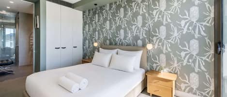 Un dormitorio moderno con una cama grande, una mesita de noche de madera y una alfombra mullida.