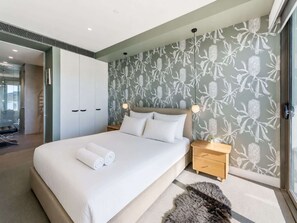 A modern bedroom with a large bed, a wooden nightstand, and a fluffy rug. - Waterfront 1-Bed Apartment in Kingston (Kingston)