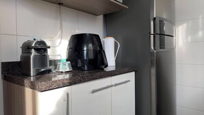 Eine Küche mit Kaffeemaschine, Wasserkocher und Kühlschrank.
