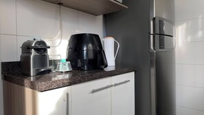 Eine Küche mit Kaffeemaschine, Wasserkocher und Kühlschrank.