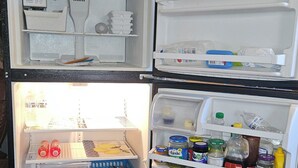 A refrigerator with multiple shelves and compartments, including a freezer section at the bottom.