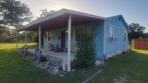 A small, single-story house with a porch, a small shed, and a bicycle. - Cabin for A&M Games, Fishing or Family Get-a-Ways! (Somerville)