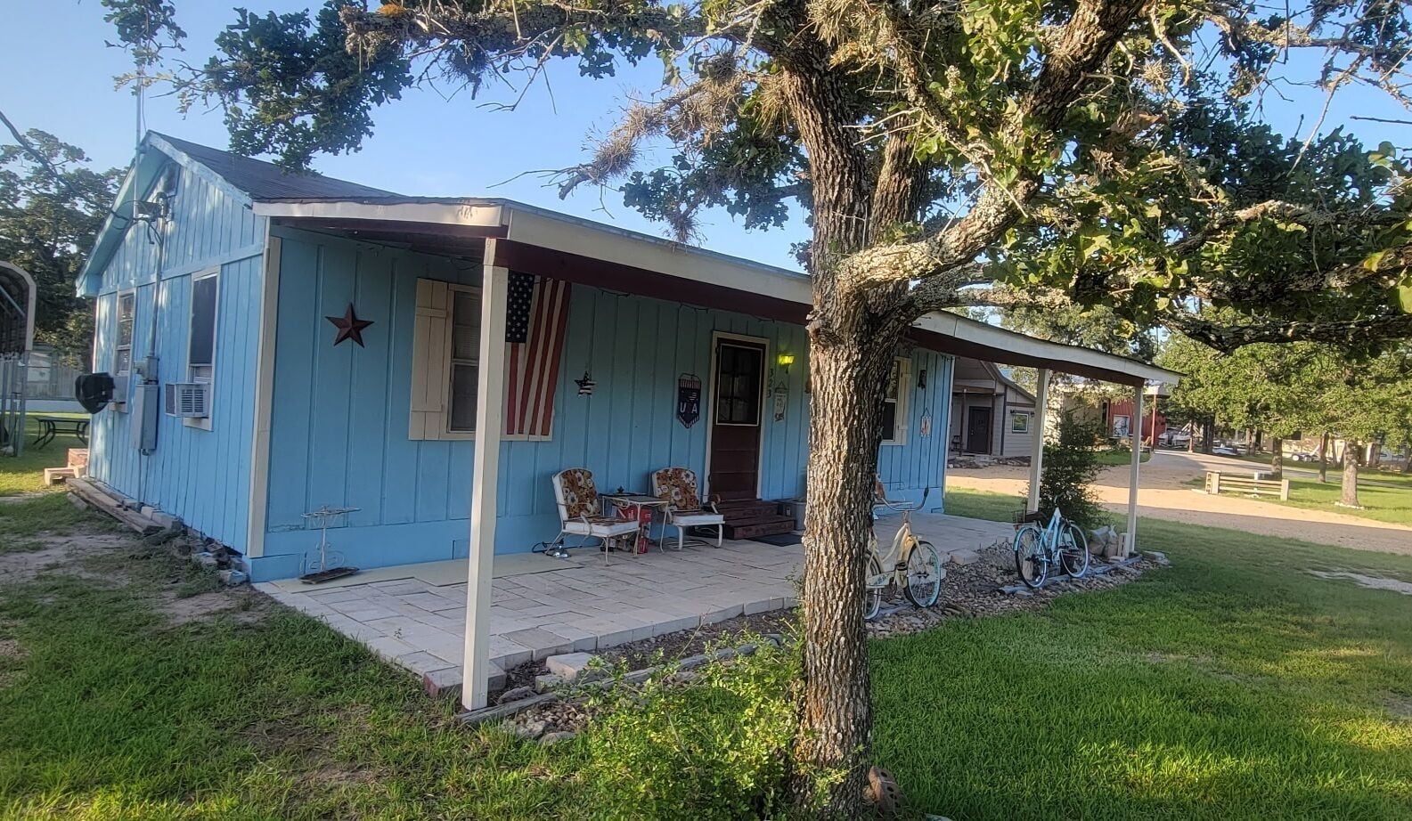 A small house with a porch, a star decoration, and an American flag.