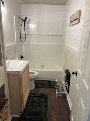 Un baño con inodoro, lavamanos y bañera.