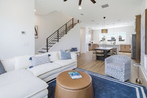 A modern living room with a staircase, a dining area, and a kitchen. - Luxury 3BR Waterfront w/ Private Rooftop Skyline Views (Jacksonville)